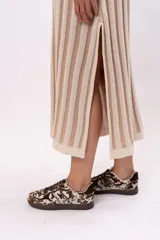 Vestido largo de punto a rayas verticales color beige y marrón claro, de corte suelto y sin mangas.