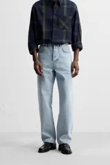 Pantalón de jean celeste de corte recto, con cinco bolsillos, efecto lavado y cierre frontal con botones.