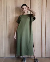 Vestido midi verde militar de corte recto, con cuello redondo y mangas cortas. Presenta aberturas laterales en el ruedo.