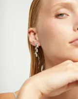 Par de aros colgantes plateados, con forma de zigzag irregular.