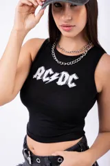Musculosa negra ajustada al cuerpo, sin mangas, con cuello redondo y el logo de la banda AC/DC estampado en blanco en el frente.