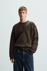 Jersey marrón con diseño jacquard pixelado en negro, de corte relaxed, cuello redondo y manga larga con terminaciones en rib.