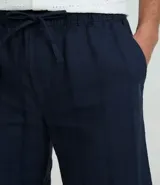 Bermuda de playa recta color mostaza, con textura de rayas y lazo en la cintura.