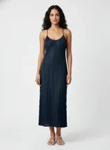 Vestido largo azul marino con textura arrugada y breteles finos ajustables. Confeccionado en tejido single jersey 100% poliéster reciclado, ofrece una textura suave, liviana y con caída natural. Su diseño de largo al tobillo y ajuste regular aporta comodidad y elegancia.