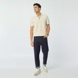 Remera polo de punto color crudo con cuello clásico, manga corta y cierre con botones de madera.