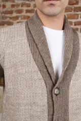 Cardigan tejido color marrón con cuello smoking, cierre con botones y bolsillos delanteros.