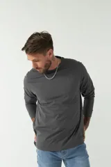 Remera gris de manga larga con cuello redondo y logo bordado en el pecho.