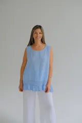 Musculosa celeste amplia y liviana confeccionada en lino italiano, con terminaciones delicadas y franja de encaje en el ruedo.