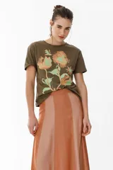Remera lila de algodón con estampado de flores en tonos naranja y rosa.