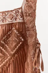 Top marrón con escote cuadrado, tirantes anchos y detalle de puntilla y bordados en forma de rombos. Aberturas laterales ajustables con lazadas.