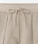 Bermuda masculina color beige confeccionada en tela french terry, con cintura elástica, cordón interior para ajustes y bolsillos cargo.