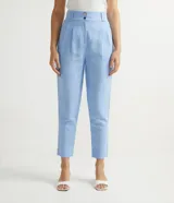 Pantalón cigarrete celeste de lino y algodón, con pliegues delanteros, bolsillos laterales, cintura con elástico en la espalda y cierre con botones metálicos.