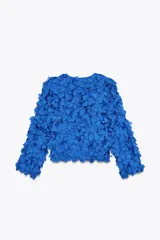 Chaqueta azul con cuello redondo y manga larga, con apliques de pétalos en toda la prenda y cierre frontal con botón a presión oculto.