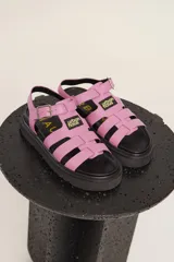 Sandalias de cuero sintético color lila con plataforma negra y tiras anchas cruzadas.