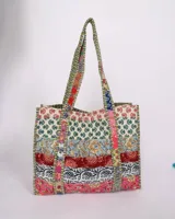 Tote bag reversible con diseño colorido y patrones florales en varios tonos.