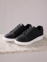 Championes urbanos negros con suela blanca.