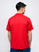 Remera polo de entrenamiento color azul marino, con cuello tipo henley de tres botones y mangas cortas. Presenta un patrón texturizado en los hombros y el escudo del Club Nacional de Football en el pecho izquierdo.