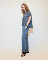 Remera celeste de lino y ramio, con corte boxy, manga japonesa, cuello mao, media cartera con broches metálicos y bolsillo plaqué con efecto de tapa.