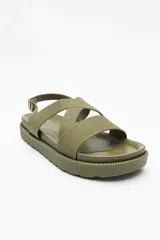 Sandalia color verde militar con tiras anchas cruzadas y hebilla metálica ajustable en el tobillo.