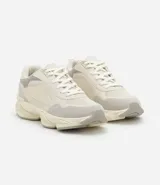 Championes dad sneaker grises con recortes en cuero sintético, cordones blancos y suela chunky de goma color crema.