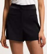 Short de sastrería corto color negro, confeccionado en crepé con detalles satinados en la cintura y los frisos. Cuenta con bolsillos incorporados y cierre delantero con cremallera.