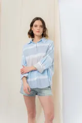 Camisa oversize de algodón liviano con estampado tie-dye a rayas en tonos pastel. Diseño suelto, manga larga con puños arremangados y botones frontales.