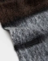 Bufanda larga con diseño a rayas horizontales en tonos marrón, gris y negro, con terminación de flecos.