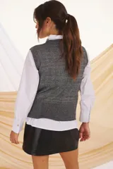 Chaleco negro con lurex plateado, de corte ajustado y diseño moderno.