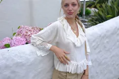 Blusa color crema de algodón con escote en V, tirantes ajustables en la espalda, mangas 3/4 con elástico en los puños y terminación en tul bordado de algodón.