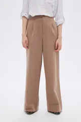 Pantalón de vestir color beige, de corte ancho y tiro alto, con pinzas en la cintura.