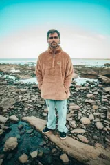 Buzo beige de corte clásico con cuello alto y cierre parcial con cremallera.