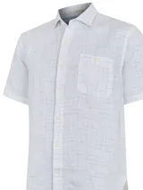 Camisa de manga corta blanca con textura multicolor, confeccionada en lino orgánico y tencel. Tiene bolsillo en el pecho con botón.