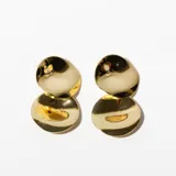 Aros tipo botón dorados con superficie irregular.