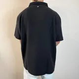Chomba color crema con cuello polo, corte oversize y tejido acanalado vertical.