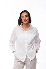 Camisa blanca de algodón con cuello clásico, manga larga y bolsillo en el pecho.
