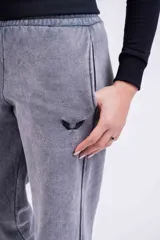 Pantalón de jogging gris con efecto lavado, corte holgado y logo bordado en negro.