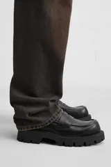 Mocasín negro de cuero con antifaz, horma cuadrada y suela track con volumen.