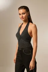 Body negro sin mangas con cuello halter, confeccionado en poliéster con strass plateados.