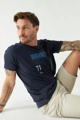 Remera blanca de algodón con estampado frontal que incluye texto en color rojo, amarillo y azul.