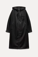 Parka larga negra con capucha ajustable con cordones, mangas largas con puños elásticos, bolsillos laterales y de plastrón en el pecho, bajo ajustable con cordón elástico y cierre frontal con cremallera metálica.