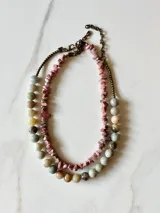 Collar hecho a mano con piedras de colores en tonalidades rosadas.