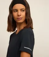 Remera deportiva blanca texturizada, con cuello redondo, manga corta, detalle reflectante y pliegue en la espalda.