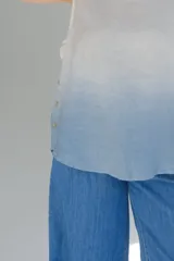 Musculosa blanca con degradé celeste en el ruedo, de corte recto y sin mangas.