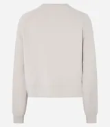 Buzo deportivo femenino confeccionado en microfibra color beige, con cuello redondo, mangas raglán largas y recortes.