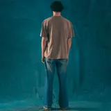 Remera oversize color beige con efecto gastado, cuello redondo y estampado pequeño en el pecho con el logo de la marca Kaboa Industries y la frase 'Más barrio que moda'.