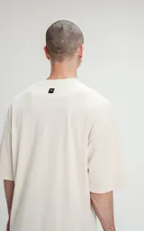 Remerón color beige de corte crop y calce oversize, con hombros caídos y cuello redondo.