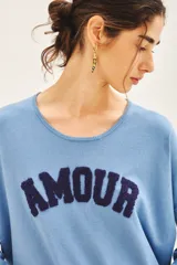 Sweater celeste de viscosa, poliéster y poliamida, de corte holgado y manga larga. Tiene bordado en buclé con la palabra 'Amour' en el frente.