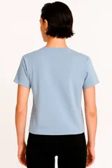 Remera blanca de algodón con estampado de flores azules y naranjas, de corte clásico y cuello redondo.