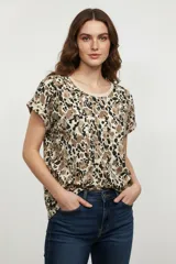 Remera de manga corta con estampado abstracto en tonos beige, marrón y negro, con cuello redondo y corte holgado.