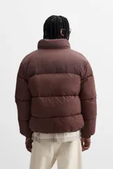 Campera puffer marrón con cuello alto, cierre frontal con cremallera, bolsillos laterales y puños elásticos.